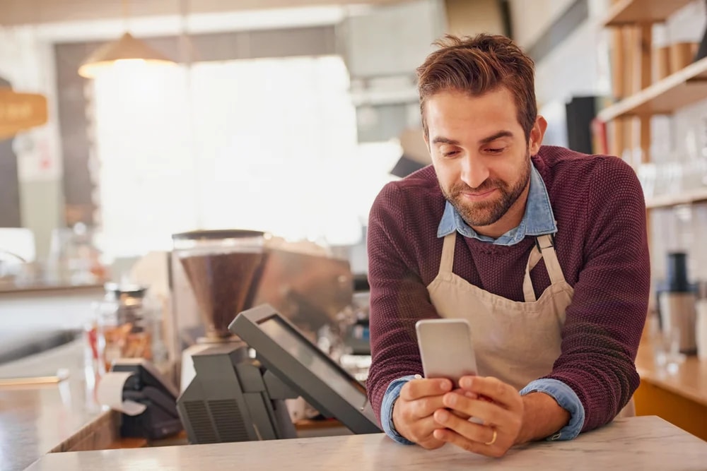 Dueño de una cafetería registrando su negocio desde el celular